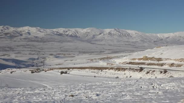 Snowy Vlakte Omgeven Door Lage Boomloze Heuvels Snowy Bergketens Aan — Stockvideo