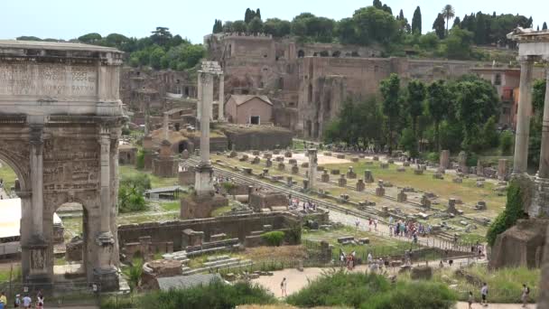 観光客はローマイタリアの歴史的観光スポットの古代遺跡を歩くツアー ローマのフォーラムは いくつかの重要な政府の建物の廃墟に囲まれた広場です 日常生活の中心 凱旋式と選挙の現場 — ストック動画