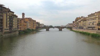 Ponte Santa Trinita, Floransa İtalya 'da Arno Nehri' ni kapsayan bir Rönesans Köprüsü. Şehir manzarası mimari mimari nehir akıntısı akışı sessiz sakin, 4K binaları inşa ederken geniş bir zum.