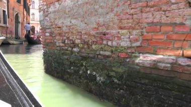 Venedik İtalya 'sında Kanallara Giden Gondol Teknesi. Gondol, Venedik lagününün koşullarına uygun geleneksel, düz tabanlı bir Venedik sandalıdır. Bu bir kanoya benziyor. Kürek kullanan bir gondolcu tarafından itiliyor, ki bu da 4K...