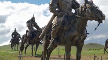 Cengiz Han 'ın atlı süvarilerinin heykelleri. Tsonjin Boldog ziyaretçi müzesi eski Xiongnu arkeolojik kültür turizm merkezi Moğol İmparatorluğu ordusu bronz metal at süvarisi süvari savaş atlısı asker 4K' ya bindi.