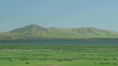 Asya 'daki alçak tepelerin önündeki düz çayırlar. Dağ sırtı tepe tepe yeşil çayır çayır çayır bozkır bozkır bozkır düzlükleri bozkır düzlükleri el değmemiş arka plan manzarası muhteşem muhteşem muhteşem muhteşem muhteşem muhteşem muhteşem muhteşem muhteşem muhteşem muhteşem bir güzellik.
