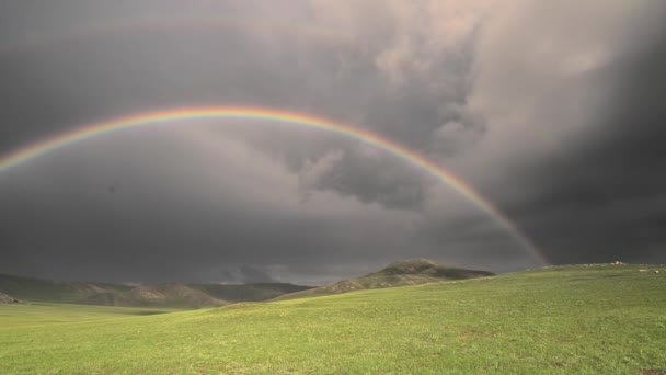 浓密的彩虹在无树的山中 强烈的硬黑色弯曲的彩色天气气象学背景圈草原草原草场草场高原高原低地平原天空光谱阳光壮丽绝妙极了 — 图库视频影像