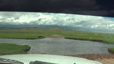 Nehir kıyısından geçen 4X4 SUV. Derin akıntı macerası tehlikeli, zorlu yol, zorlu toprak yol büyük uzun çılgınlık safariye batan doğal araç kokpiti macera dolu off-road sularına doğru gidiyor.