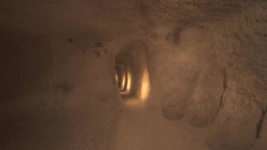 Yeraltı şehirlerinin odalarını birbirine bağlayan uzun bir koridor. Yeraltı sığınma evi, kiler kiler, drenaj kanalları mağaranın içindeki dar yol, taş devri, tarih öncesi neolitik ev arkeolojisi 4K