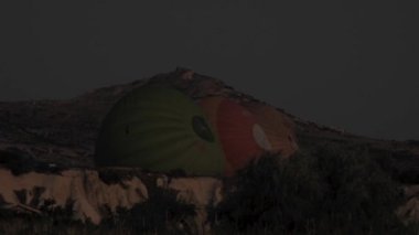 Güneş doğmadan bir gece önce sıcak hava balonları şişirmeye yönelik hazırlıklar. Yakıcı, insan yapımı uçuş. Kara zeplin hava gemileri, aerosta, enflasyon, yolcu paraşütü, yolcu havacılığı, termal mürettebat, tatil tatili macerası için havalandırma havalandırması havalandırıyor.