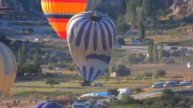 Sıcak hava balonu yolculuğunun sonunda yere iner ve şişer ve söner. Sıcak hava balonlarını söndürmeye yönelik hazırlıklar. Sıcak hava balonu, ısıtmalı seyahat çantası adı verilen bir çantadan oluşan, havadan hafif bir uçaktır.