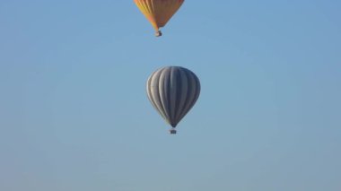 Goreme Vadisi Kapadokya 'sında uçan sıcak hava balonları ve peri bacaları. Yükselen insan taşıyan Urgup uçağı havası hasır sepet ısı enflasyonunu askıya aldı.