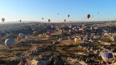 Goreme Vadisi Kapadokya 'sında uçan sıcak hava balonları ve peri bacaları. Yükselen insan taşıyan Urgup uçağı havası hasır sepet ısı enflasyonunu askıya aldı.