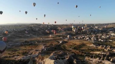 Goreme Vadisi Kapadokya 'sında uçan sıcak hava balonları ve peri bacaları. Yükselen insan taşıyan Urgup uçağı havası hasır sepet ısı enflasyonunu askıya aldı.