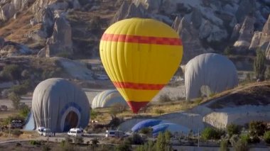 Sıcak hava balonu yolculuğunun sonunda yere iner ve şişer ve söner. Sıcak hava balonlarını söndürmeye yönelik hazırlıklar. Sıcak hava balonu, ısıtmalı seyahat çantası adı verilen bir çantadan oluşan, havadan hafif bir uçaktır.