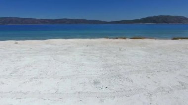 Deniz kıyısındaki beyaz kumlu sahil. Tropikal sahil sahili, sahil kıyısı, bozulmamış sahil kıyısı, deniz kıyısı, deniz kıyısı, kıyı manzarası, deniz manzarası, muhteşem güzellik, hava manzarası, manzara, doğa, 4K düz.