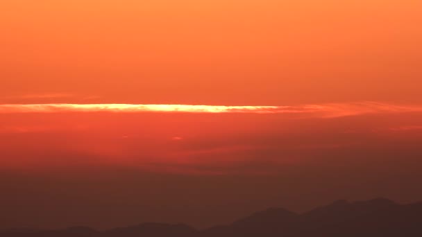 薄いオレンジ色の雲の下にぼんやりとした空気の中で朝日が昇る 夜明けに朝日が昇る早朝時間の前日裸のシンプルな映画的背景風景自然霧霞湿った4K — ストック動画