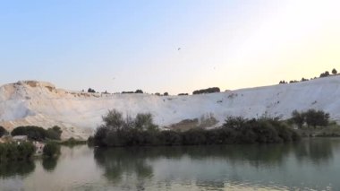 Pamukkale 'nin travertinelerinde planörlü planör, turistik doğal dünya mirası. Asma planör askıya alınmış havacılıkların üzerinden uçuyor, sabah termal şişirme, zeplin, aerostat özgürlüğü, aşırı kalsiyum, 4K