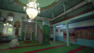 Müslüman cami öğretmeni cübbe ve türbanla küçük tarihi ahşap mescitte dua ediyor. İçsel mistik insanlar, tanrıya dua ediyor. Gizemli dini İslam müslümanlığı, ibadet yeri Endonezya Pakistan Hindistan Bangladeş Türkiye Libya