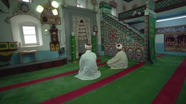 Müslüman cami öğretmeni cübbe ve türbanla küçük tarihi ahşap mescitte dua ediyor. İçsel mistik insanlar, tanrıya dua ediyor. Gizemli dini İslam müslümanlığı, ibadet yeri Endonezya Pakistan Hindistan Bangladeş Türkiye Libya