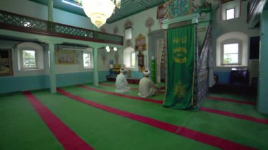 Müslüman cami öğretmeni cübbe ve türbanla küçük tarihi ahşap mescitte dua ediyor. İçsel mistik insanlar, tanrıya dua ediyor. Gizemli dini İslam müslümanlığı, ibadet yeri Endonezya Pakistan Hindistan Bangladeş Türkiye Libya