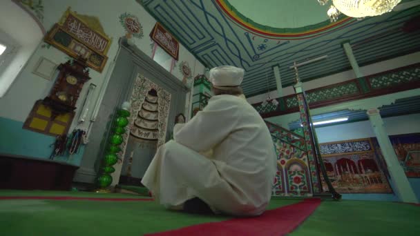 小さな歴史的な木製のマスジドでのローブとターバンでのイスラム教徒のモスク教師 内部の神秘的な人々は神の宗教を祈る神秘的な宗教イスラム教のイスラム教のイスラム教の礼拝の場所インドネシアパキスタンインドバングラデシュトルコリビア — ストック動画