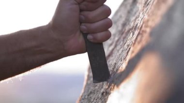 Antik insan mağara resimleri ve kaya yüzeyine demir oymacılığı ile tarihi grafiti yazıları. Taş oyma ustası, taş yontma ustası, tarih öncesi ilkel anıt menhirs obelisk megalith heykelini şekillendiren çalışmalar yapıyor..
