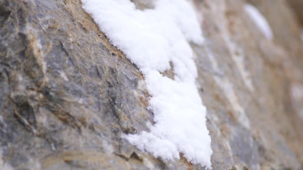 雪の層は 冬の厳しい嵐の寒さの中で岩の上に蓄積します 石の嵐のサフリ山の雪氷の表面氷の凍結風の風自然白最初の霜山平野斜面尾根丘陵の丘のピーク頂上を閉じます — ストック動画