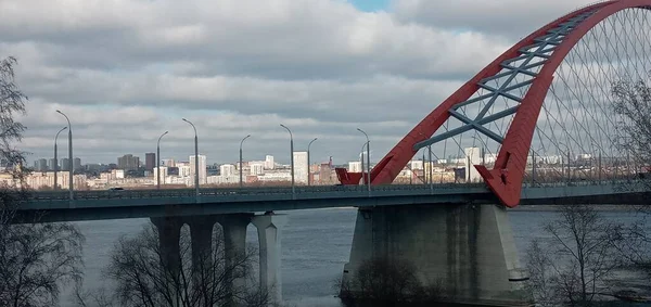 Arc rouge du pont suspendu à haubans au-dessus de la large rivière Ob. Novossibirsk, Russie. — Photo