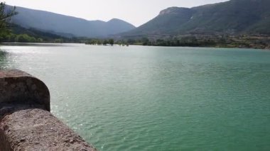 Bir göl manzarası ve arka planda dağlar