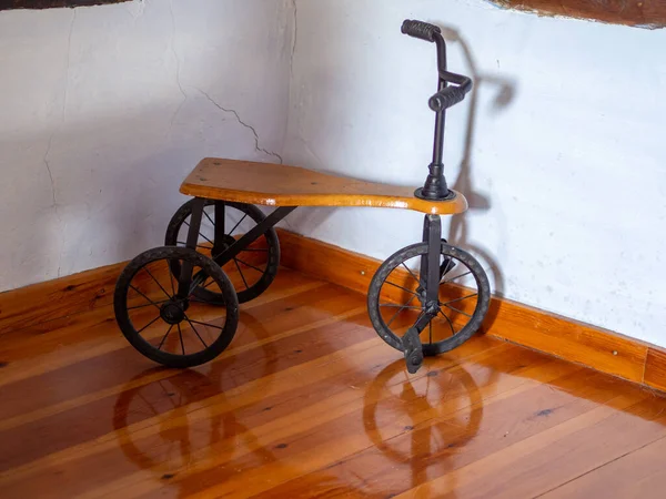 古い金属三輪車 子供のための木製自転車のおもちゃ ロイヤリティフリーのストック写真