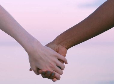 Farklı ırktan insanlar arasında ırklar arası sevgi jesti, el hareketi.