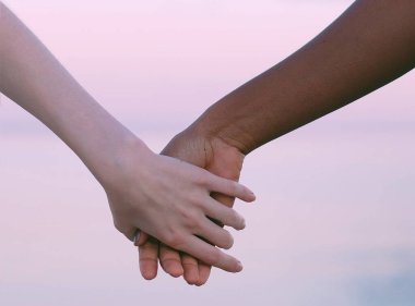 Farklı ırktan insanlar arasında ırklar arası sevgi jesti, el hareketi.