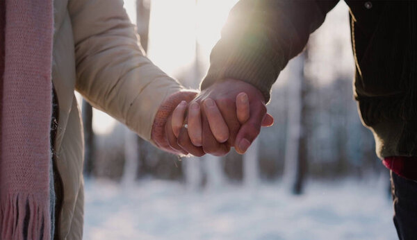 двое влюбленных идут рука об руку на пляже на закате. Крупный план, влюбленная пара, держащая за руки винтажный тон. Пары держатся за руки. Мы будем любить вас и заботиться о вас вечно.