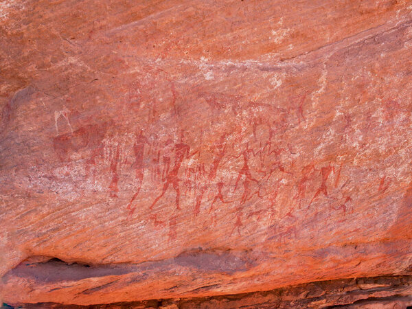 Prehistoric rock paintings and engravings of the Tadrart Rouge on sandstone walls in the Sahara Desert. African cultural heritage site.
