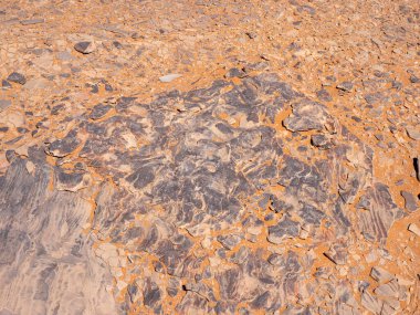 Kızıl Tadrart 'ın çöl manzarası. Mavi gökyüzünün altında kaya oluşumları ve altın kum. Cezayir Sahra 'sının doğal manzarası.