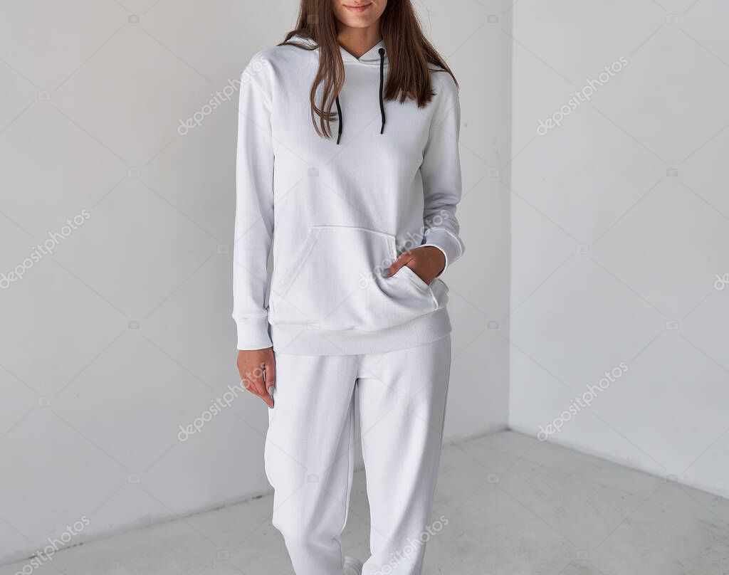 Girl wears white sportswear. copy space clothes without a logo. woman wears white hoodie and white pants