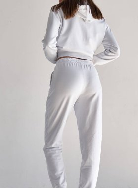 fit kız beyaz pantolon giyer. İç mekan stüdyo kıyafet fotoğrafı.