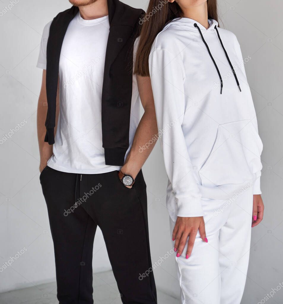 man and woman standing in white hoodies. mock up for clothing branding.