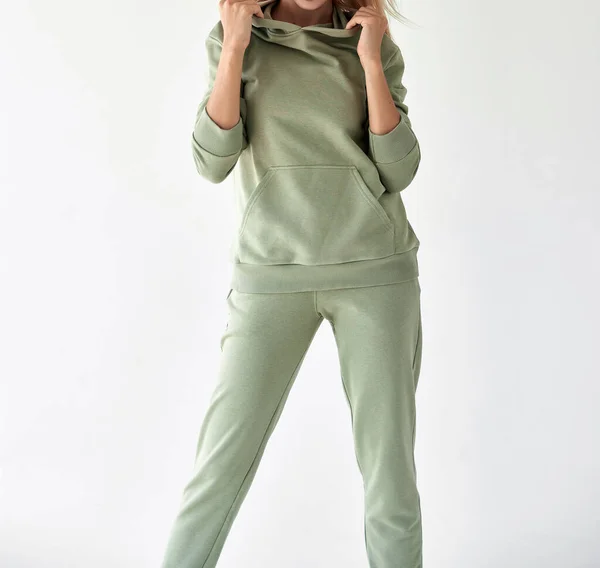 女孩穿着浅绿色的帽衫和裤子 体育服装销售工作室拍摄 — 图库照片