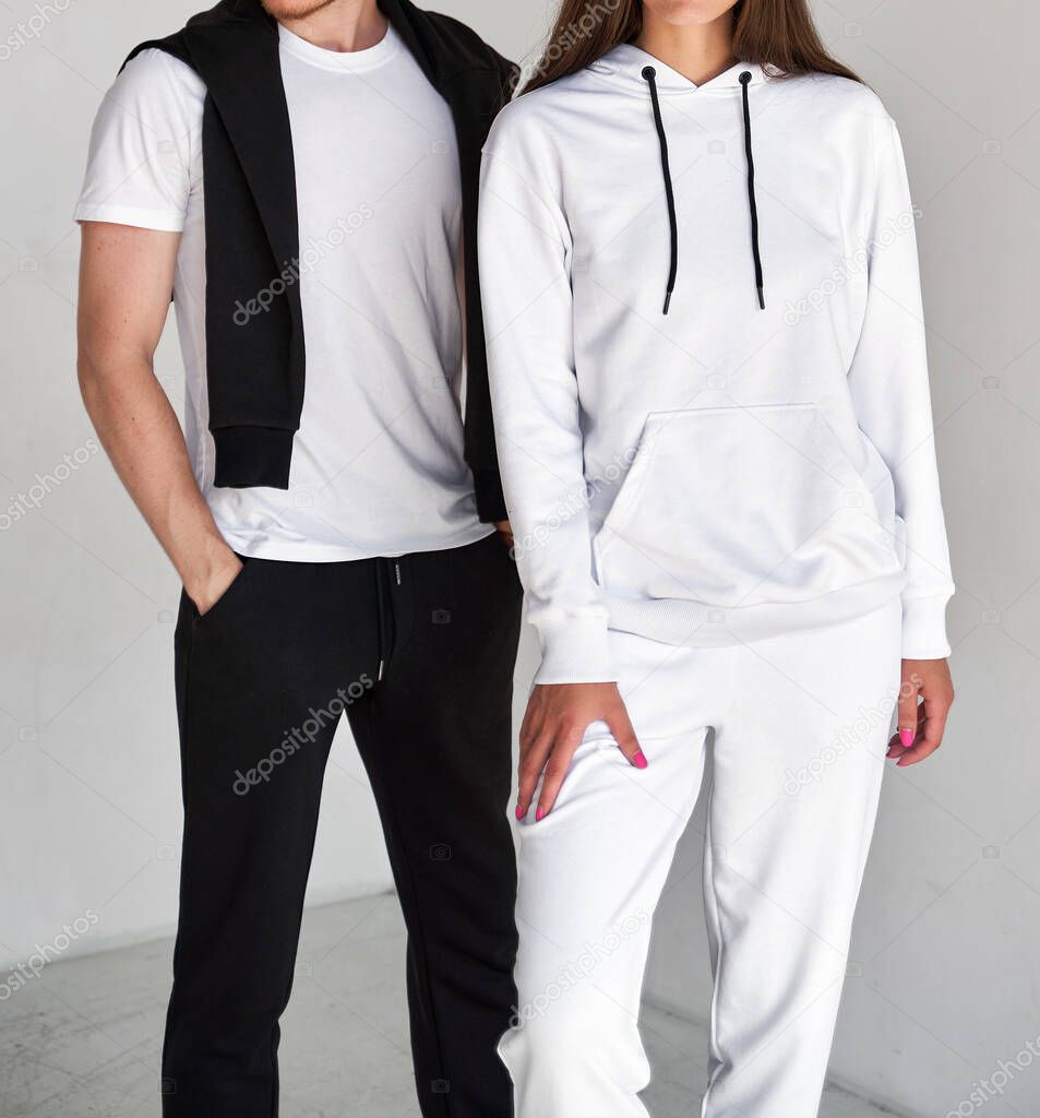 man and woman standing in white hoodies. mock up for clothing branding.