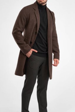 Adam kahverengi palto giyiyor. Koyu kahverengi paltolu şık bir adamın izole edilmiş bir stüdyo resmi.