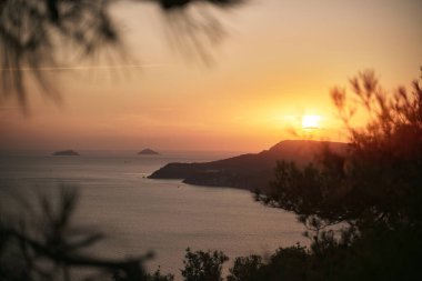 Denizin üzerindeki uzak yarımadada gün batımı
