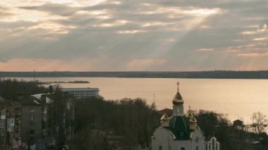 Nehirdeki Doğu Ortodoks Kilisesi 'nin zaman çizelgesi. Gökyüzü Tanrı ışınlarıyla hareket ediyor. Altın kubbeli kilisenin çöküşü. Kilisenin kubbesi gökyüzünü yansıtıyor.