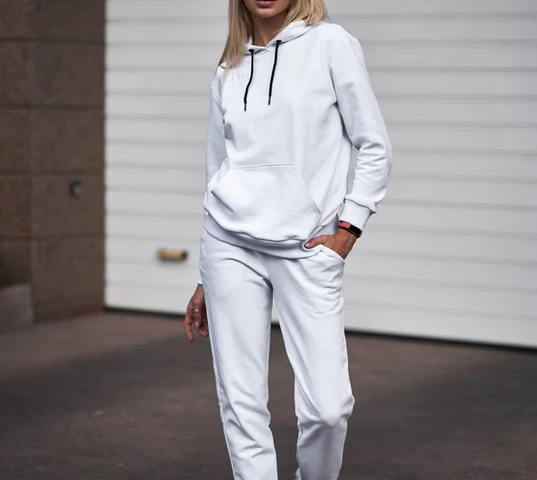 for Girl wears white hoodie and pants. Blonde woman in loose tracksuit with no logo