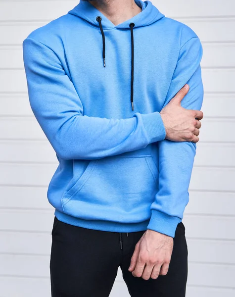 髭を生やした男がフーディの中に立っていた ロゴのないライトブルーのスウェットシャツ デザインモックアップ — ストック写真