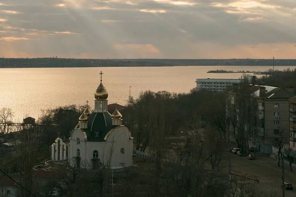 the church with golden domes. Dome of the church reflecting floating sky. Aerial image of the Eastern Orthodox Church on the river
