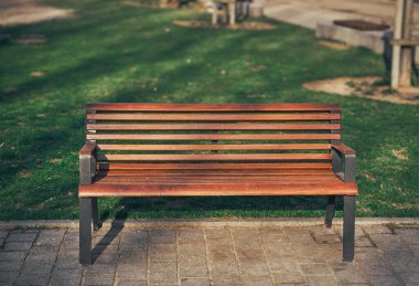 Kamu parkında üzerinde güneş olan boş bir bank. Şehir altyapı tasarımı maketi