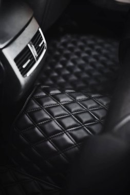 Modern arabanın ikinci sıradaki lüks deri döşeme paspasının kapağını kapatın. Havalandırma delikli panel