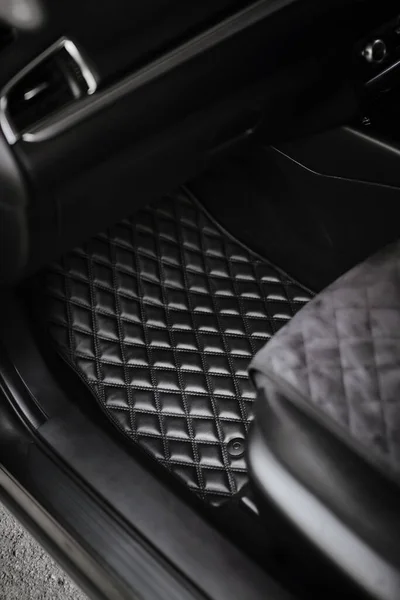 leather floor mat with diamond shape texture. eco leather luxury floor mat on the front row car interior.