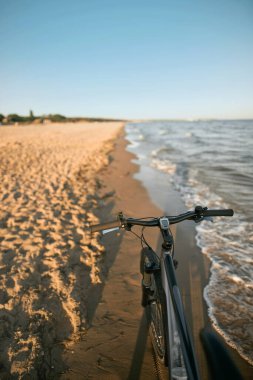 Sahilde bisiklet sürerken çekilmiş konsept fotoğraf. Kum sahilinde bisiklet sürerken yaz maceraları.