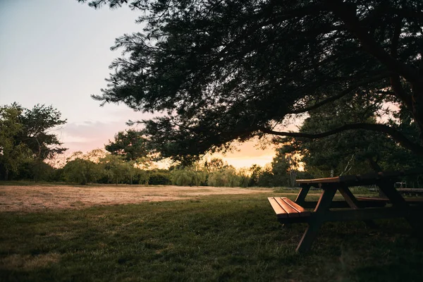 暖かい天気の間 素晴らしい日没の空の間に公園内の公共の屋外家具 屋外で食べるための座席とテーブル付きの都市公園 — ストック写真
