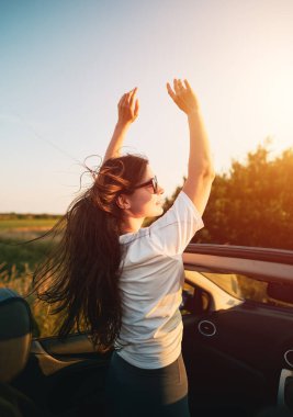Çekici esmer bir kadının üstü açık arabada sürüşünün dikiz aynası. Yaz maceraları ve yeni deneyimler kavramı. Sıcak ve uzun yaz akşamlarında güçlü güneş ışığı.