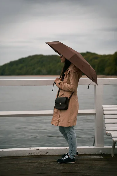 Girl with the umbrella on a sea vacation during bad weather